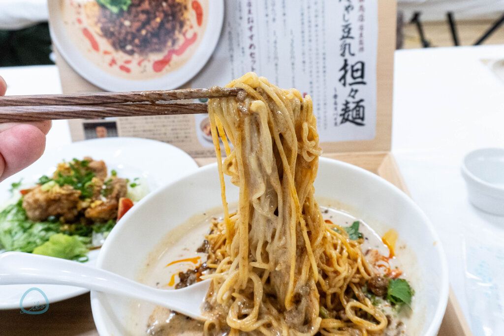 デニーズ×飯田商店　冷やし豆乳担々麺　面をすする様子