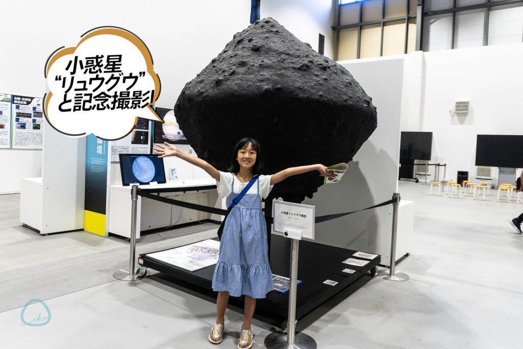 JAXA宇宙科学研究所 宇宙科学探査交流棟 小惑星リュウグウの模型の前に立つ女子