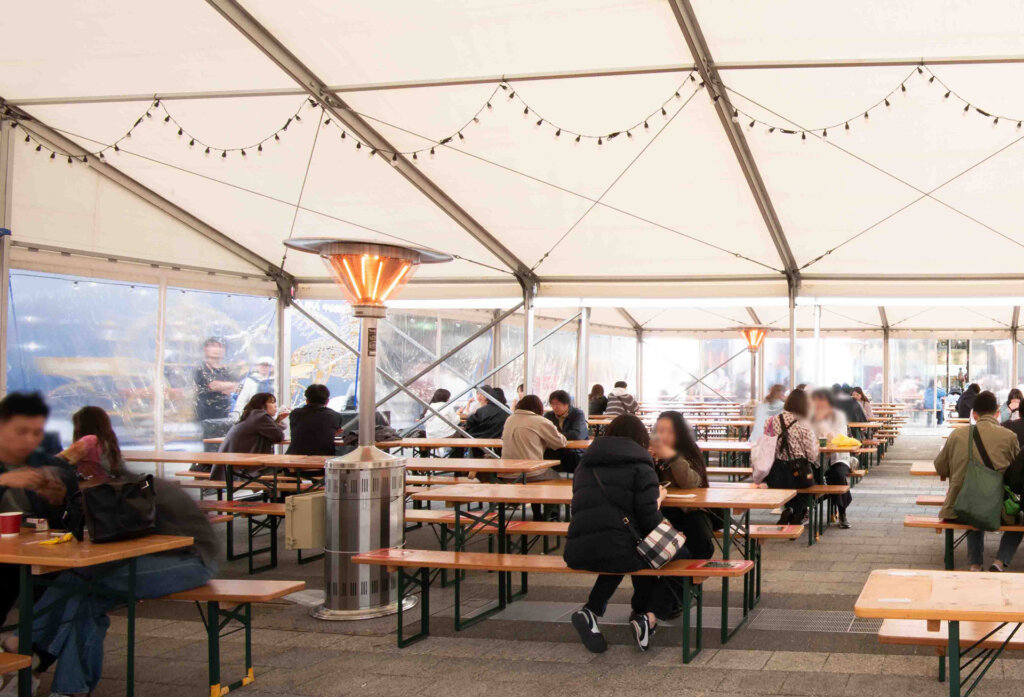 暖房のきいたテント内で休憩する人々