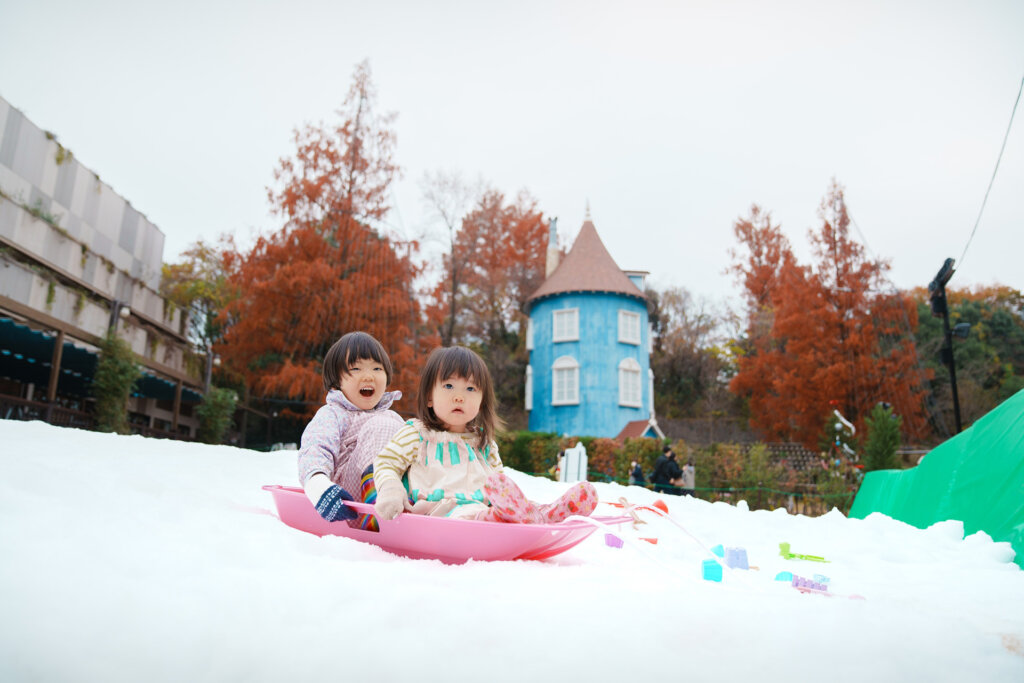 ムーミンバレーパークでソリをする子ども