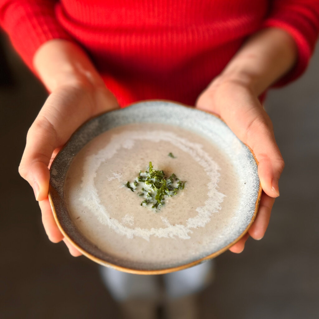 スープを差し出す女性