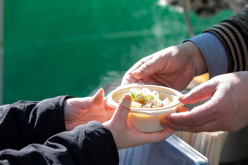 スープを差し出す女性