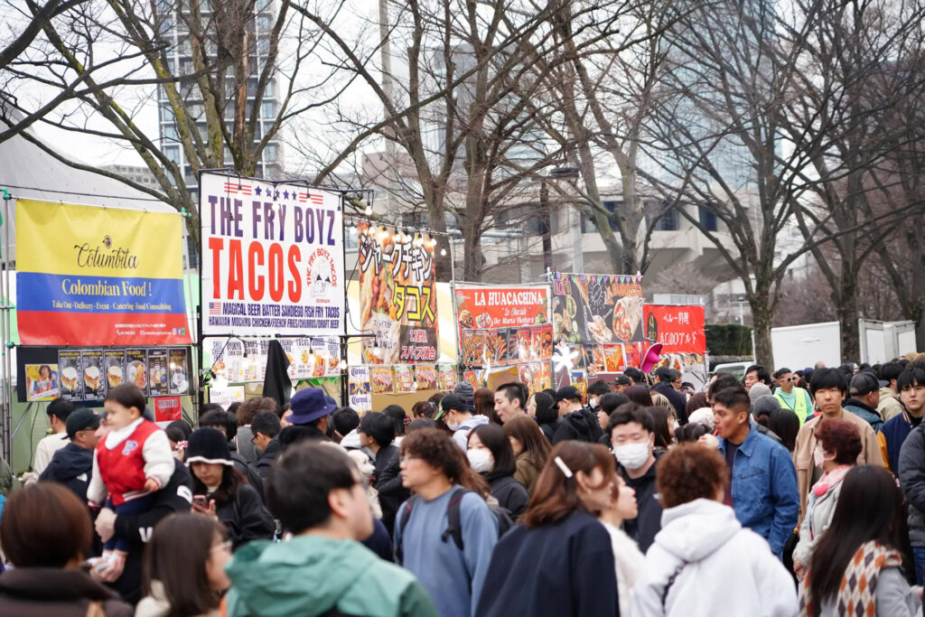 野外フェスの飲食ブースに並ぶ人々
