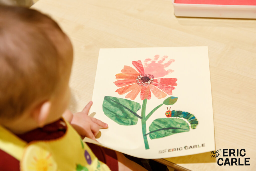 花のイラストに手形を押す赤ちゃん