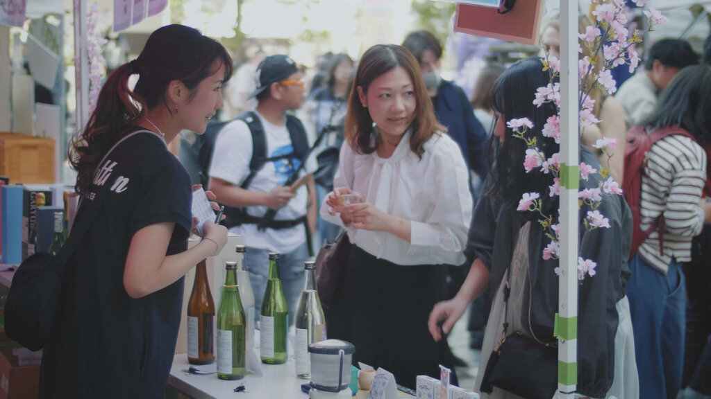 お酒のブースでスタッフと談笑する女性