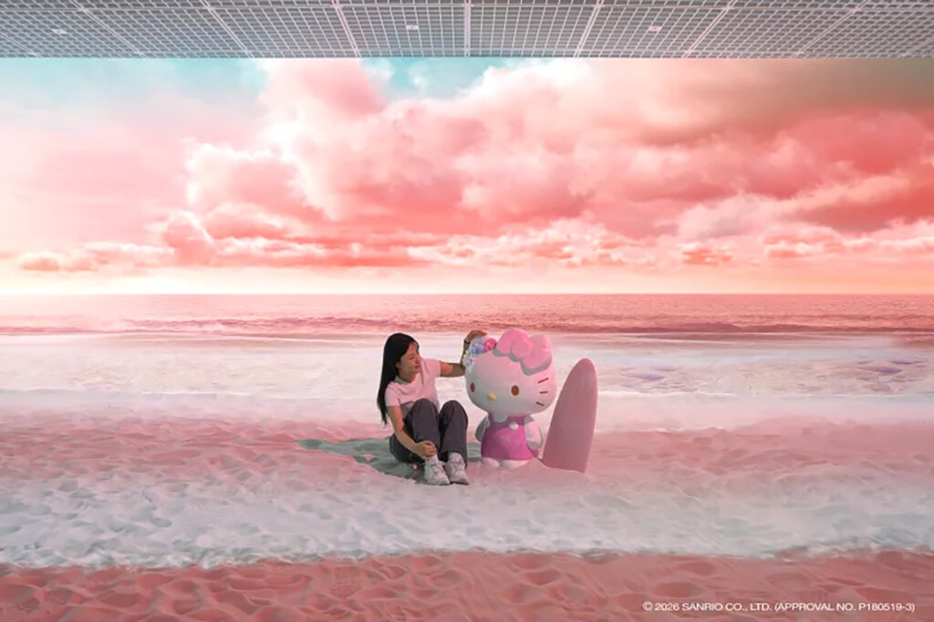 浜辺のキティちゃんをなでる女性