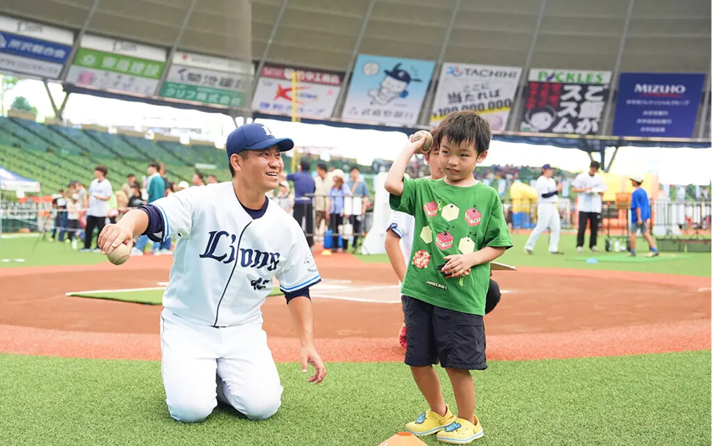 ライオンズ選手の元でボールを投げる子供