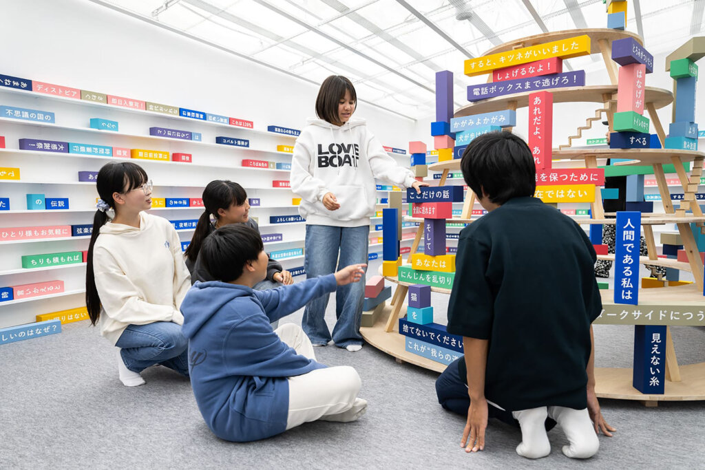 文字が書かれたカラフルなブロックで遊ぶ男女
