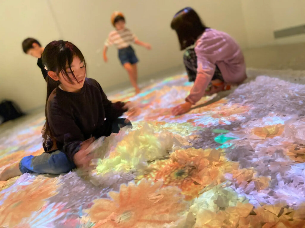 花壇の中の紙吹雪を舞い上げ、花を咲かせる子ども