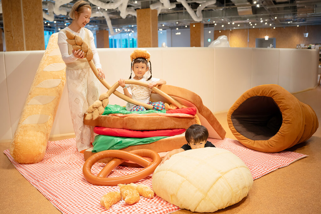 パンのぬいぐるみで遊ぶ子ども