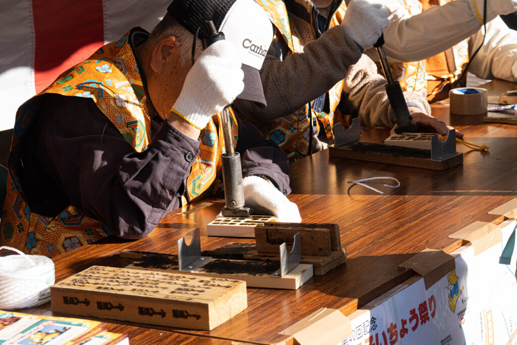 八王子いちょう祭りで通行手形に焼き印を押す人